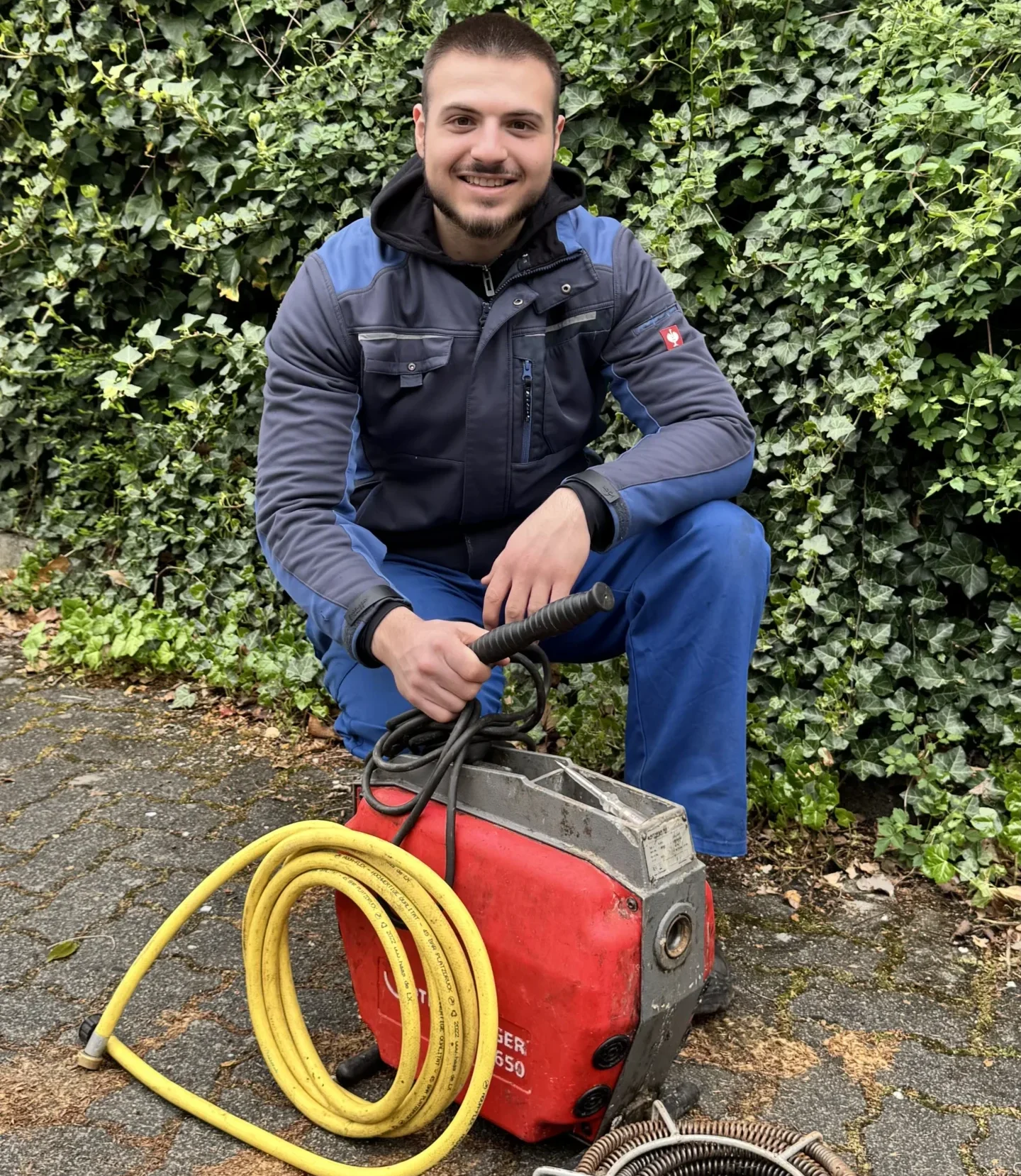 Mitarbeiter reinigt Abfluss mit Rohrreinigungsspirale in Düsseldorf